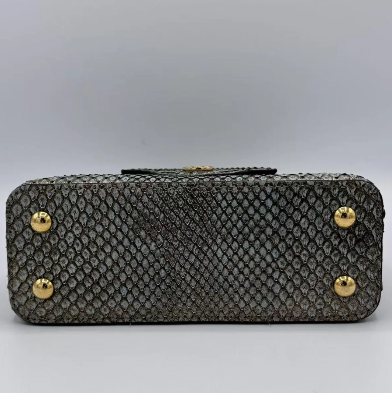 Textured handbag with gold footing on a light gray background