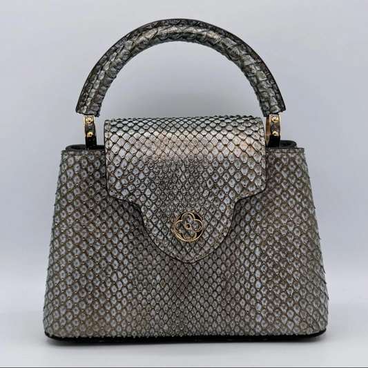 Silver textured handbag with a gold clasp on a light gray background