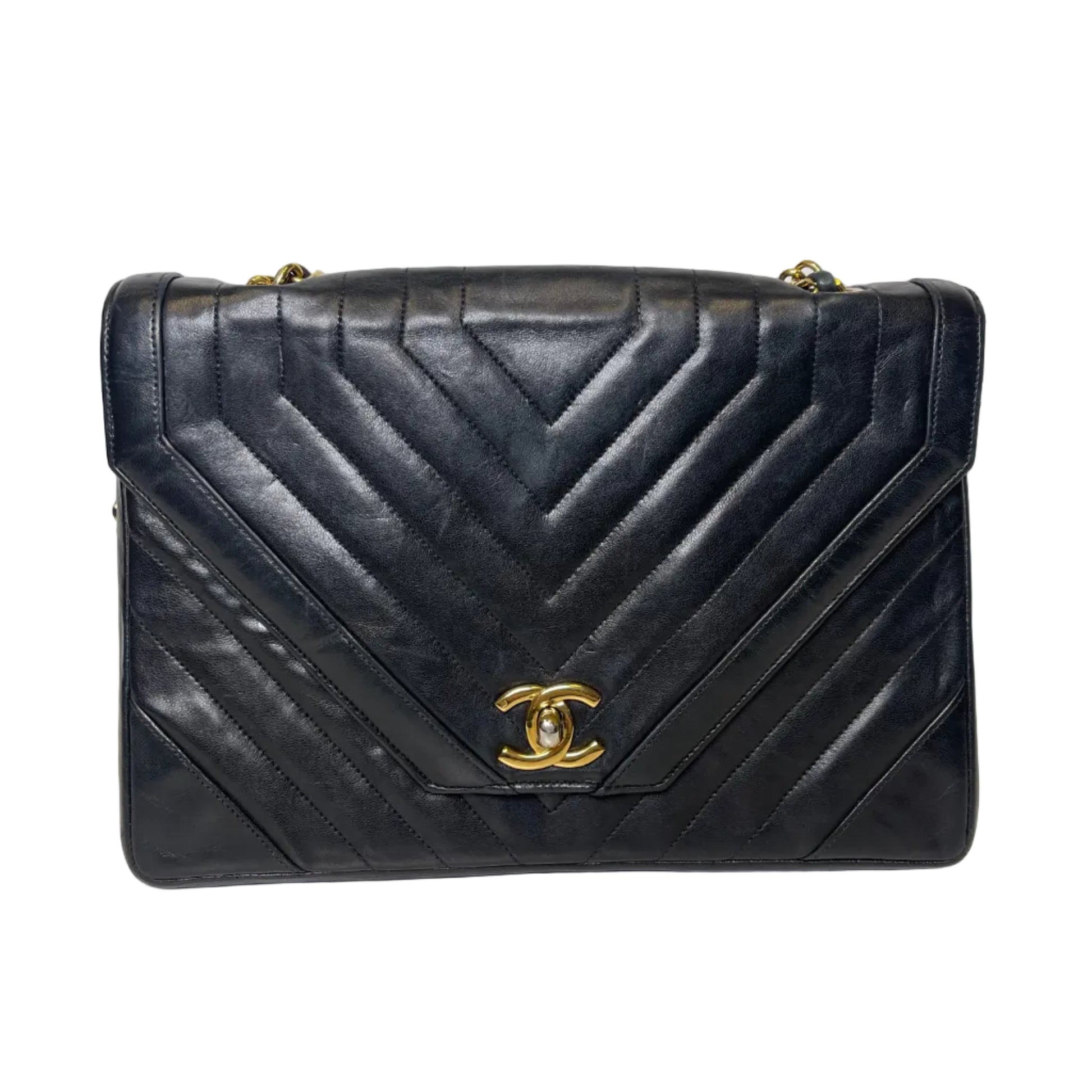 Black quilted handbag with gold Chanel logo on a light gray background